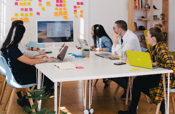 A group of people sitting around a table in an office