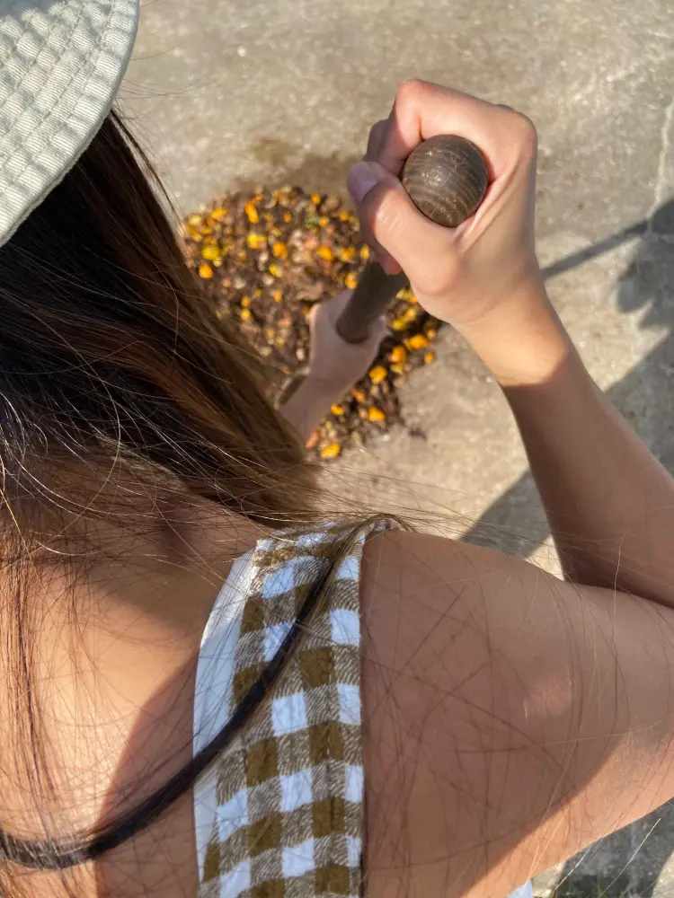 A person chopping food scraps with a shovel.