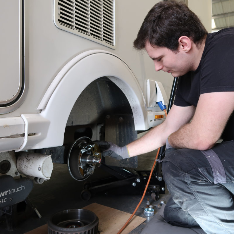 Picture of service technician servicing a touring caravan braking system
