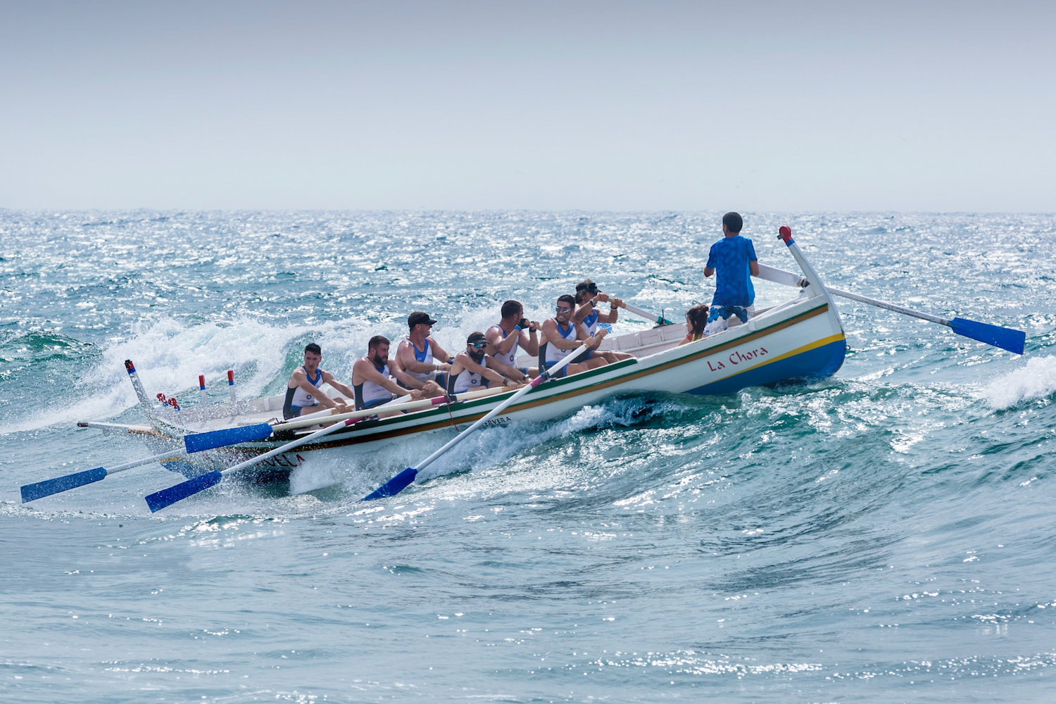 Surf rescue row boat cresting wave
