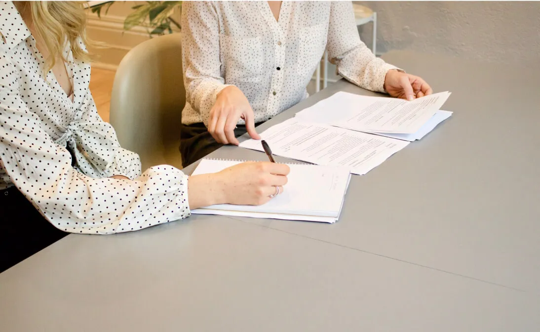 two people writing a form