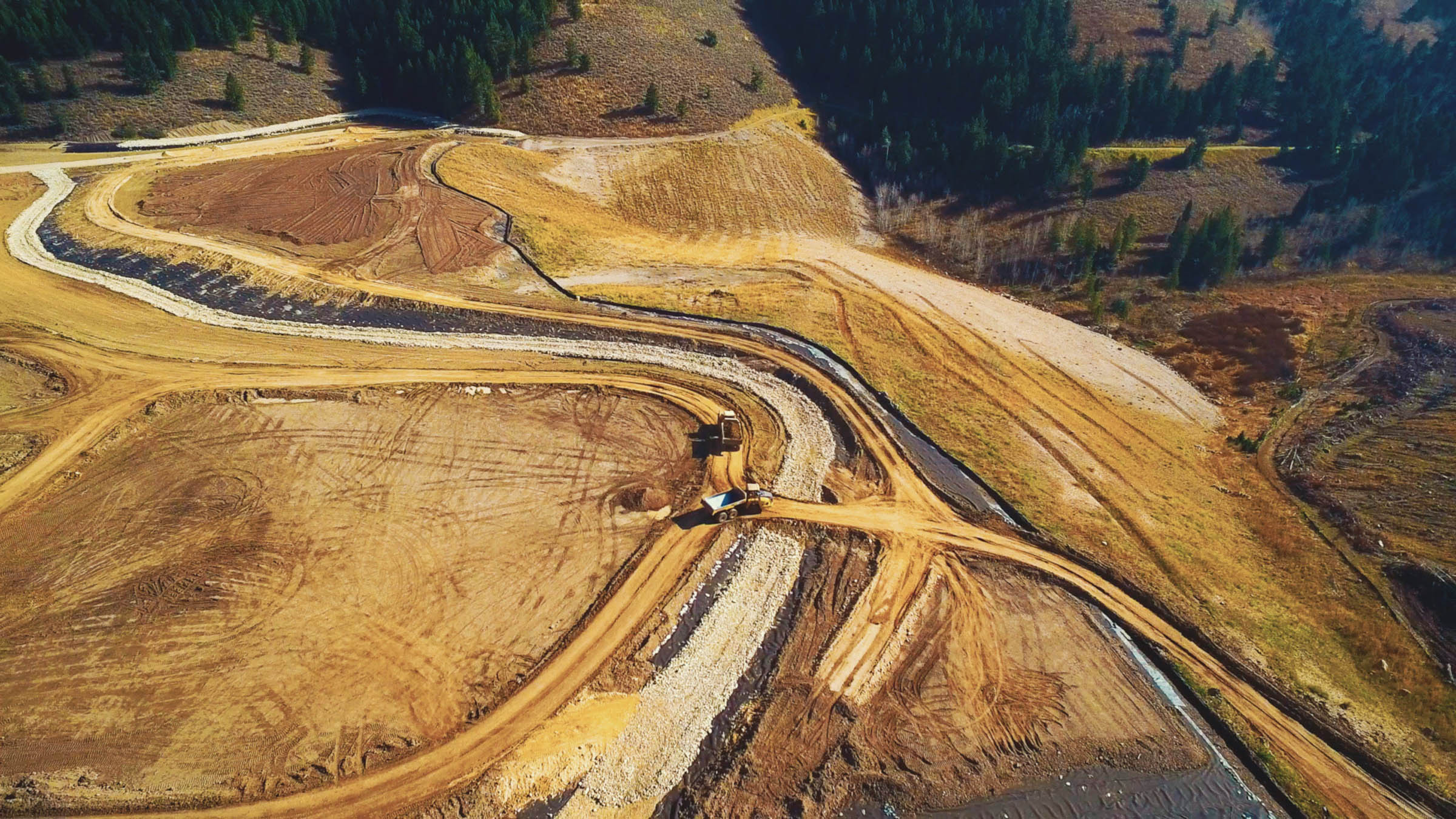 an aerial view of dirt tracks in hills