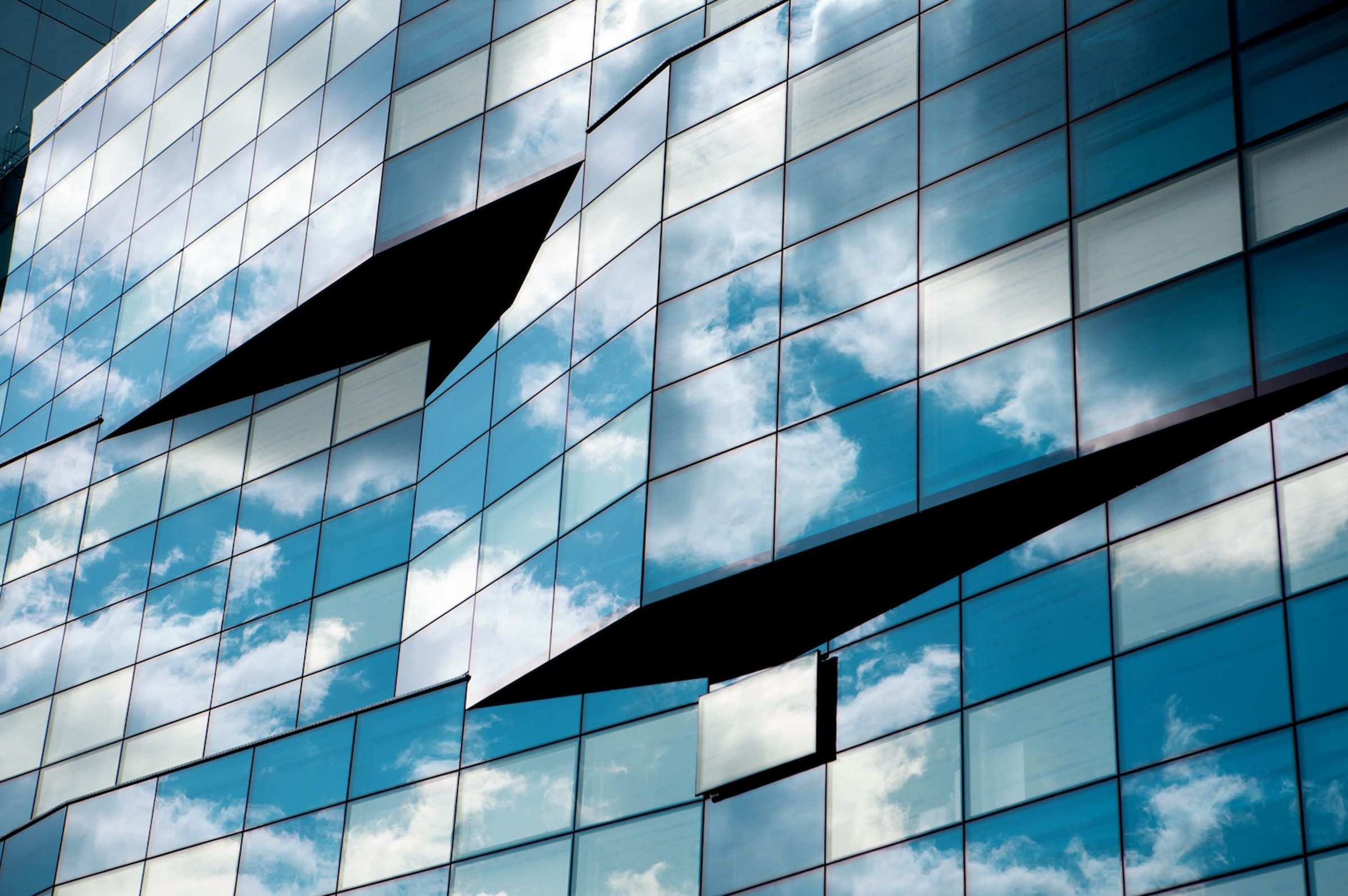 reflection of clouds on a glass sided corporate building