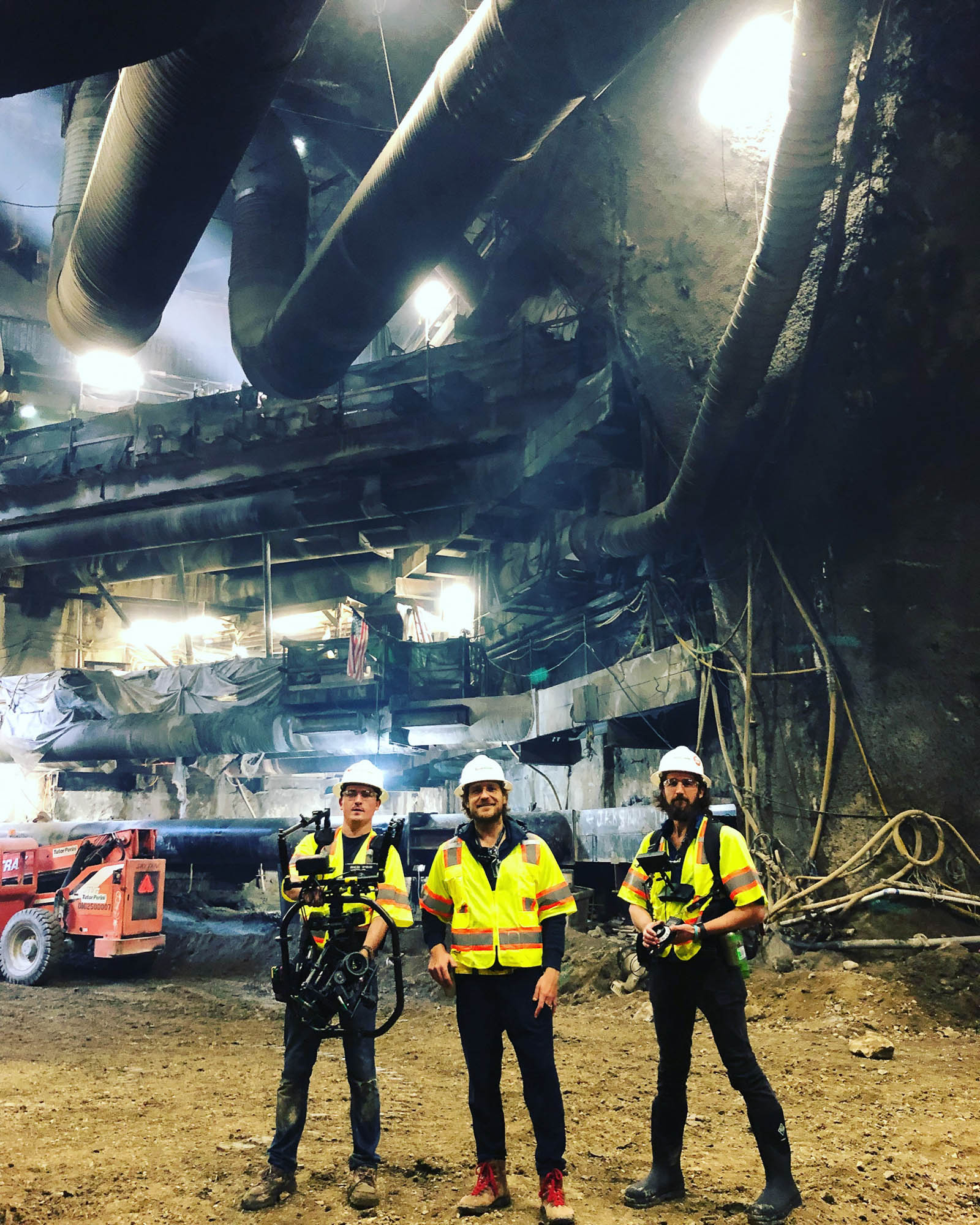 several workers in construction gear working with large equipment