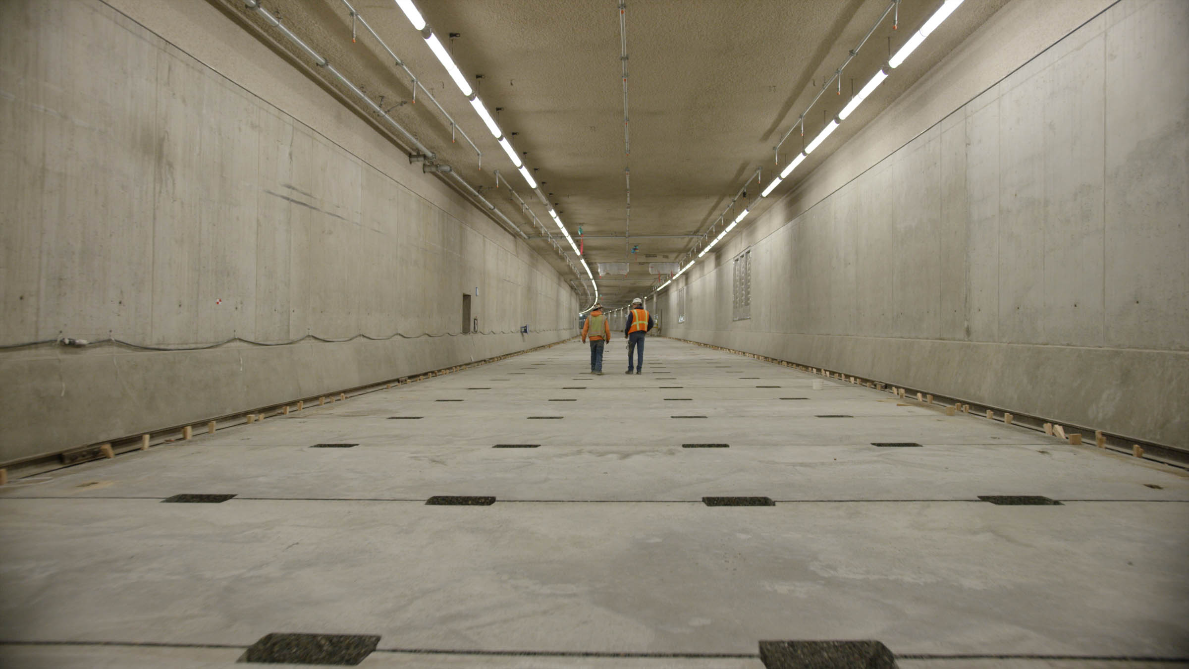 a few men walking through a large tunnel