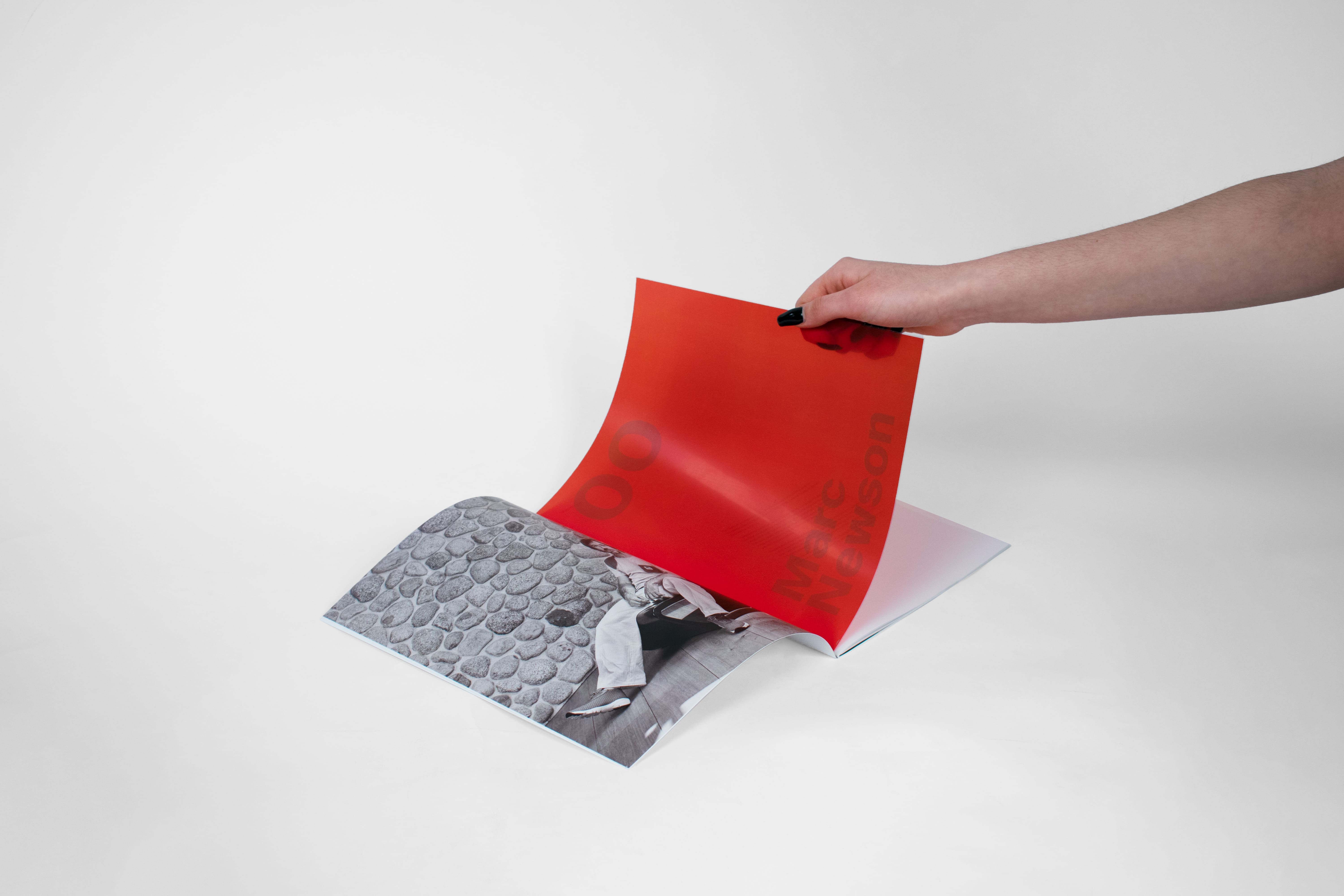 Hand turning a red acetate page in a book.