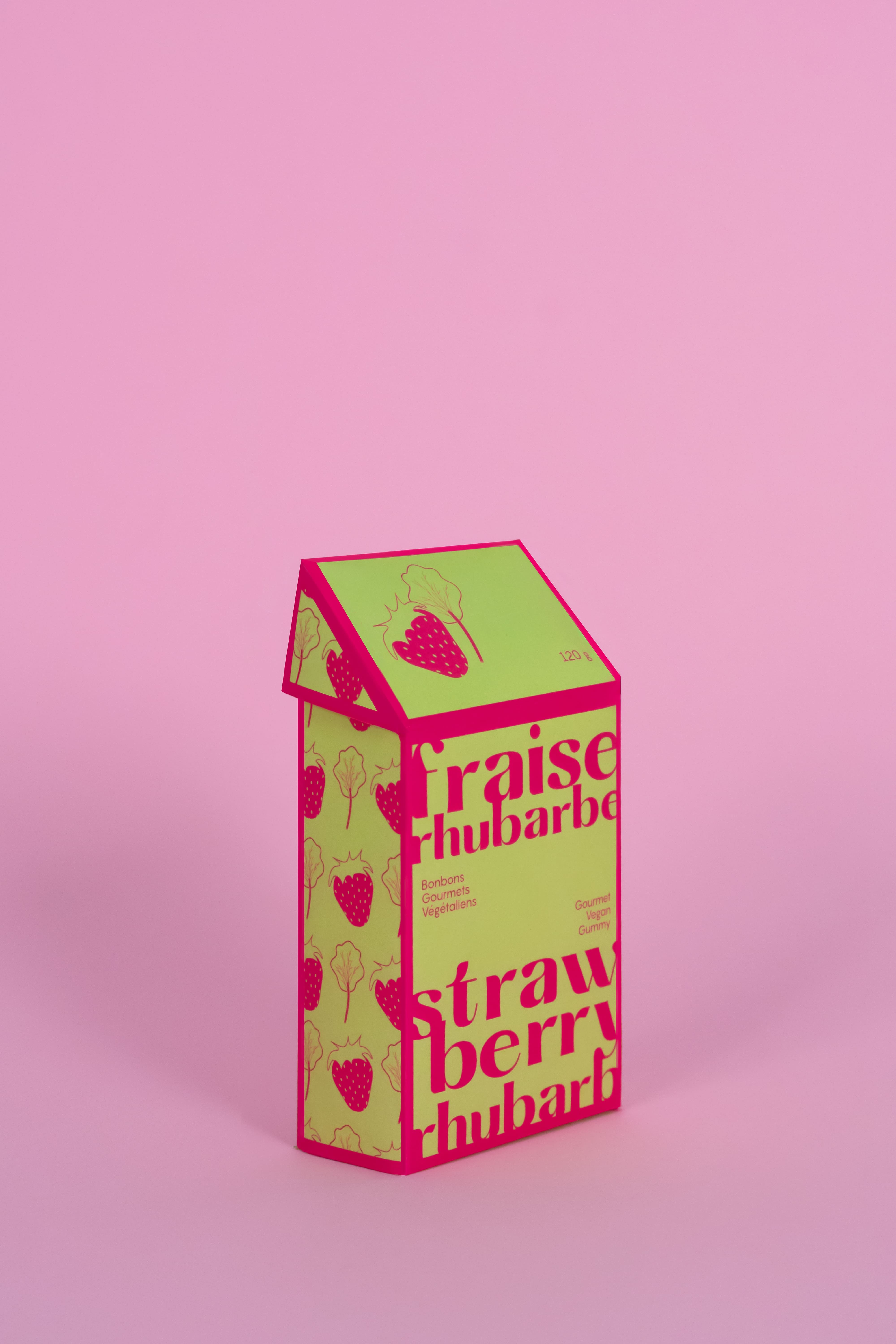A green and pink candy package on a light pink background.