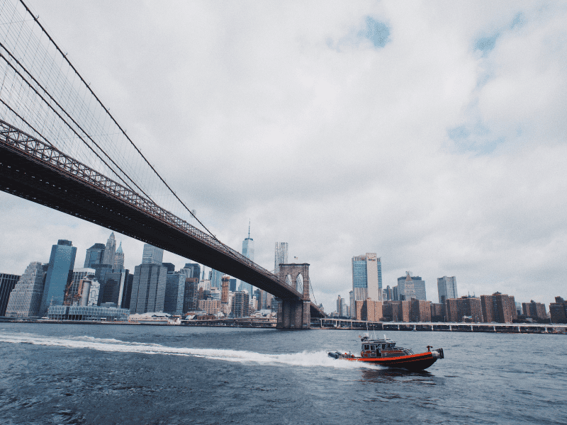 A security boat passing under a bridge in New York City