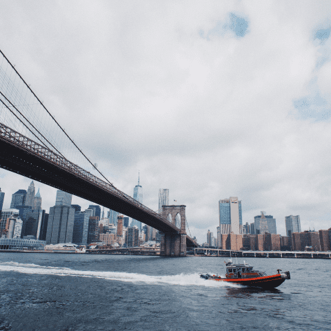 A security boat passing under a bridge in New York City
