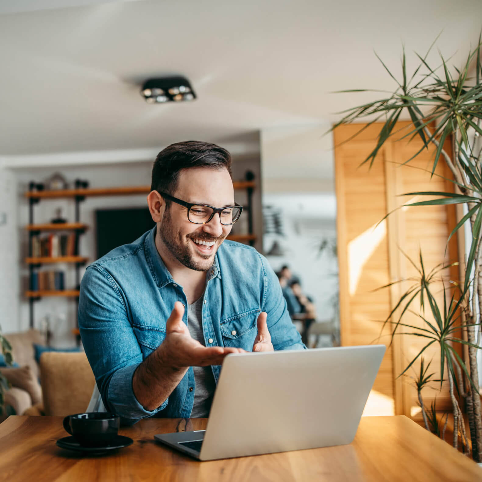 A man in a blue shirt and glasses is using his laptop to connect with the Duratus Inner Circle.