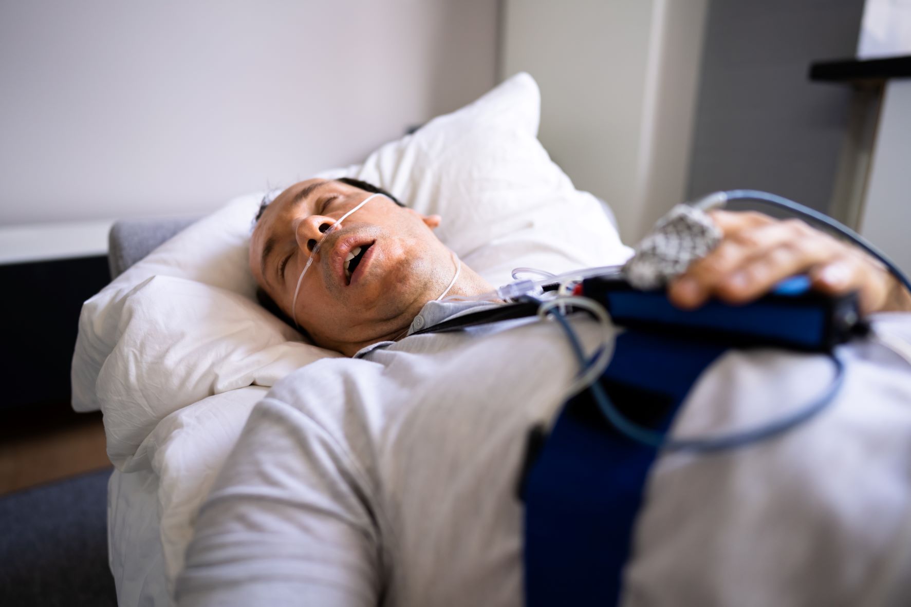 A subject undergoes a sleep test with various wires and sensors.