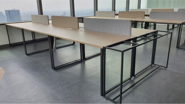 Multiple workstations with wooden top table and metal legs.