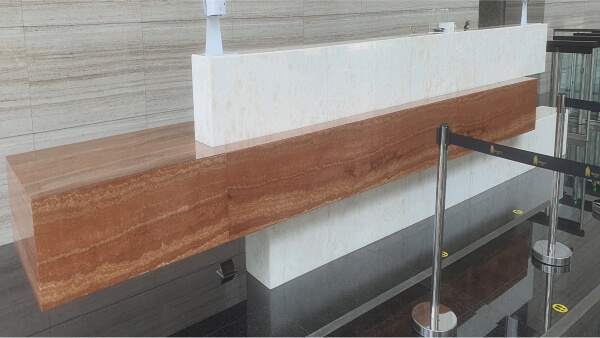 Big reception desk with a brown marble top.