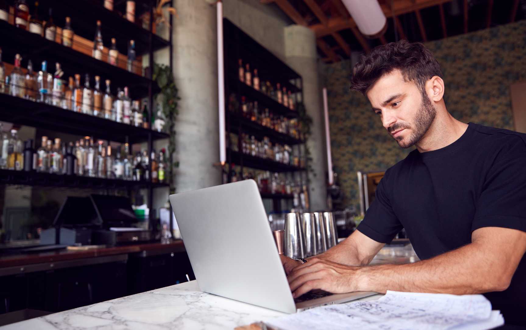man sitting on his laptop looking at a stock management app for pc