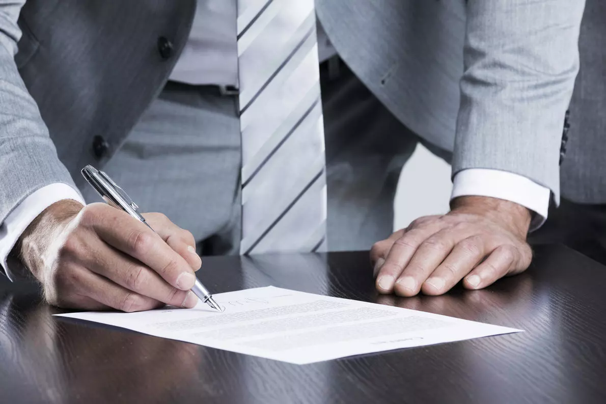business man in grey suit sign contract