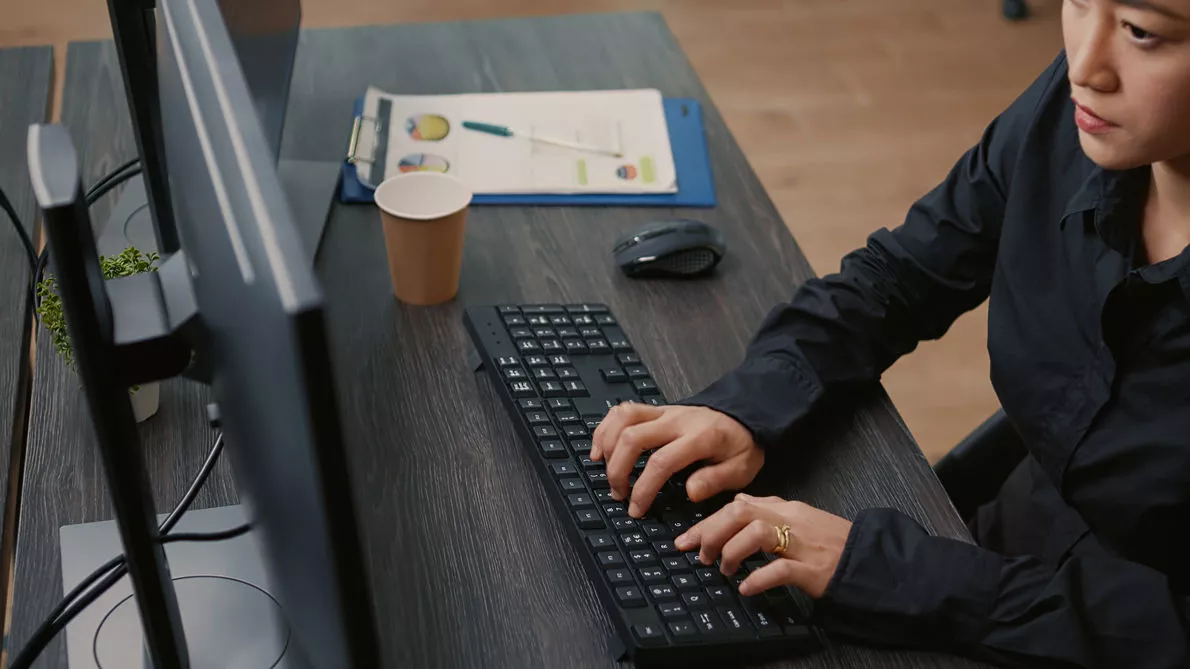 female typing on keyboard while looking at computer screen