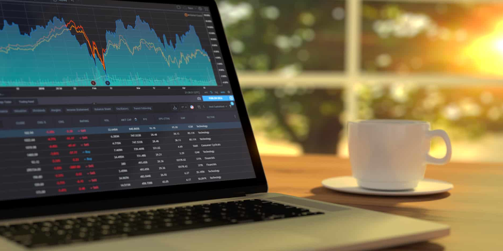 A photo of a laptop with share tracking information on it and a cup of coffee resting on a table. It's implied that this is an investor's laptop, and so they would base investments in part off a company's technical due diligence