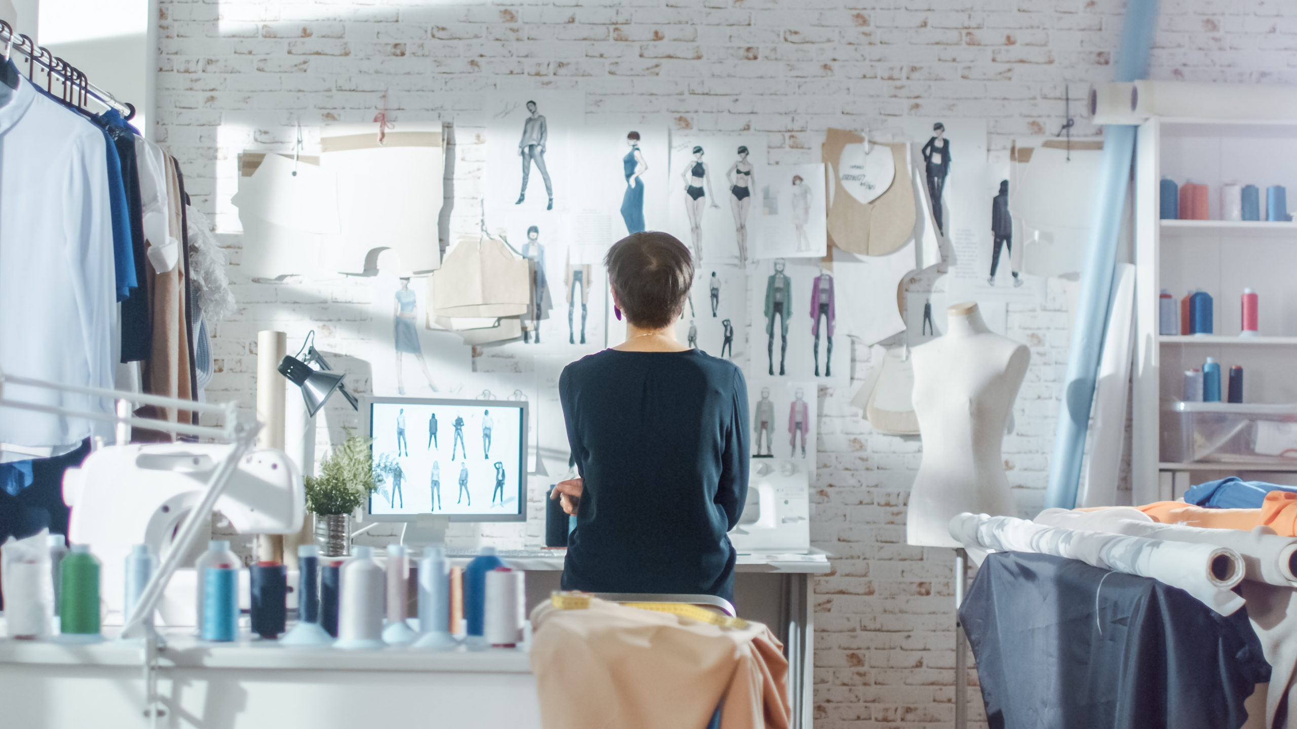 A product design team member looking at a wall of sketches
