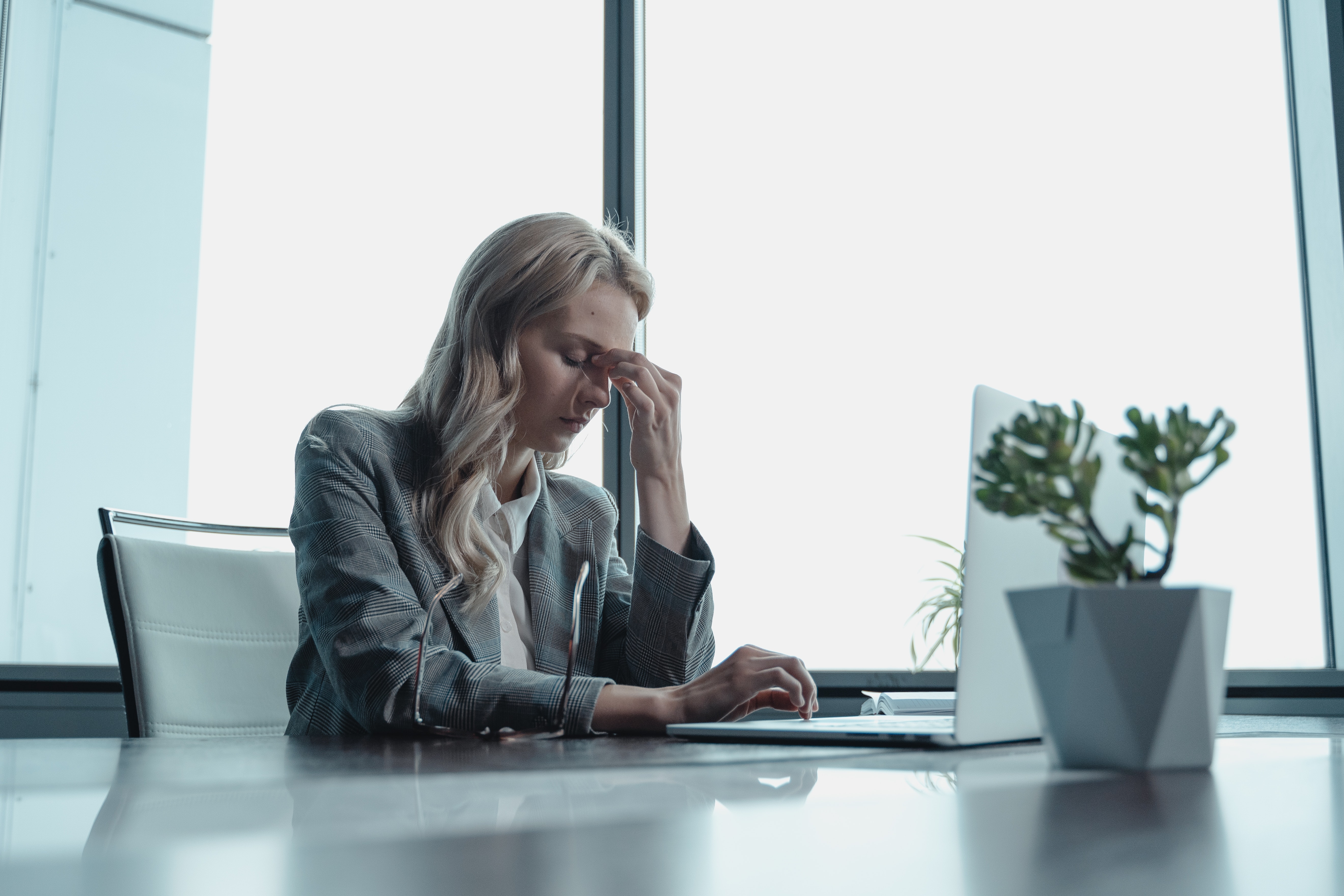 A female inventory management personnel stressfully looking at a laptop