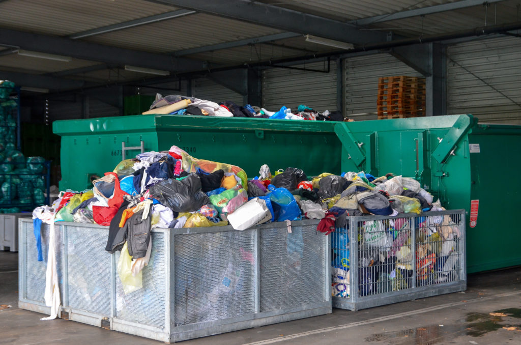 Dumpsters full of textile waste, detrimental to fashion sustainability