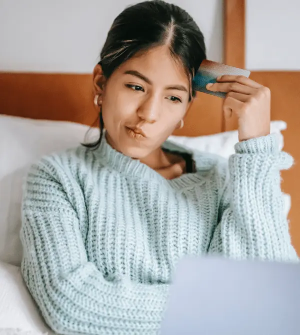 an online clothes shopper sitting at their laptop looking confused