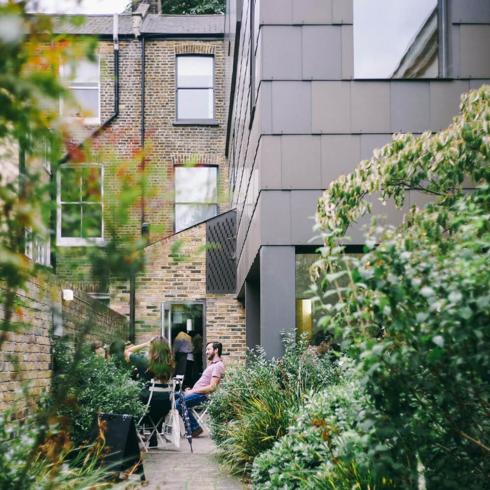 people walking on a path between buildings