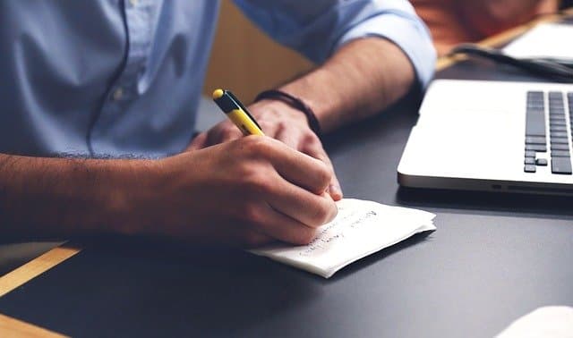 Homme qui écrit sur un bureau