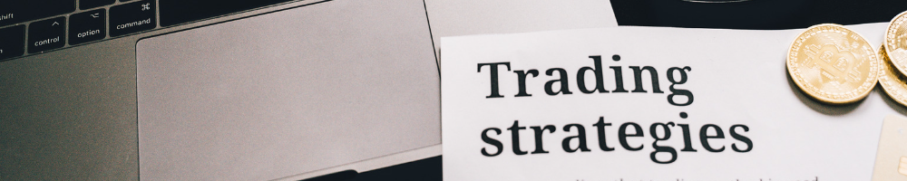 A computer with a paper saying Trading Strategies for the best trading course.