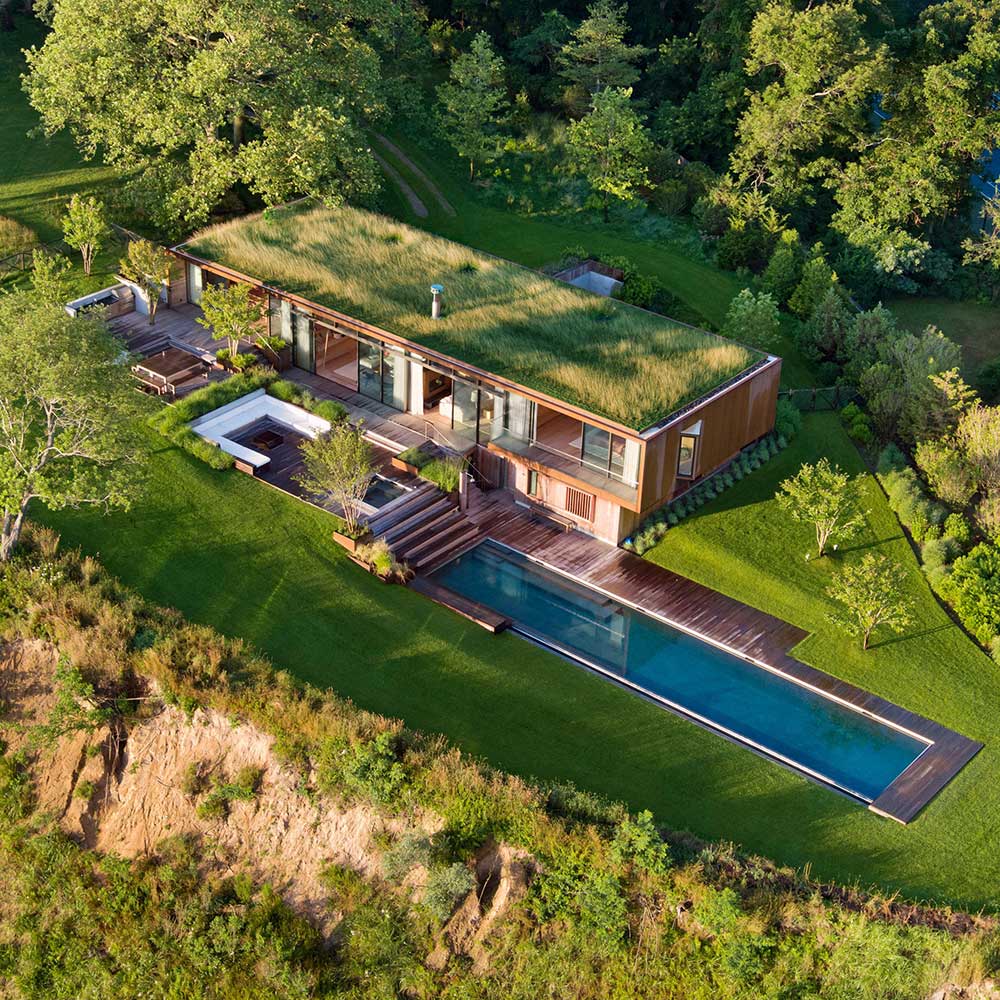 Casa de madeira com telhado verde no meio da natureza