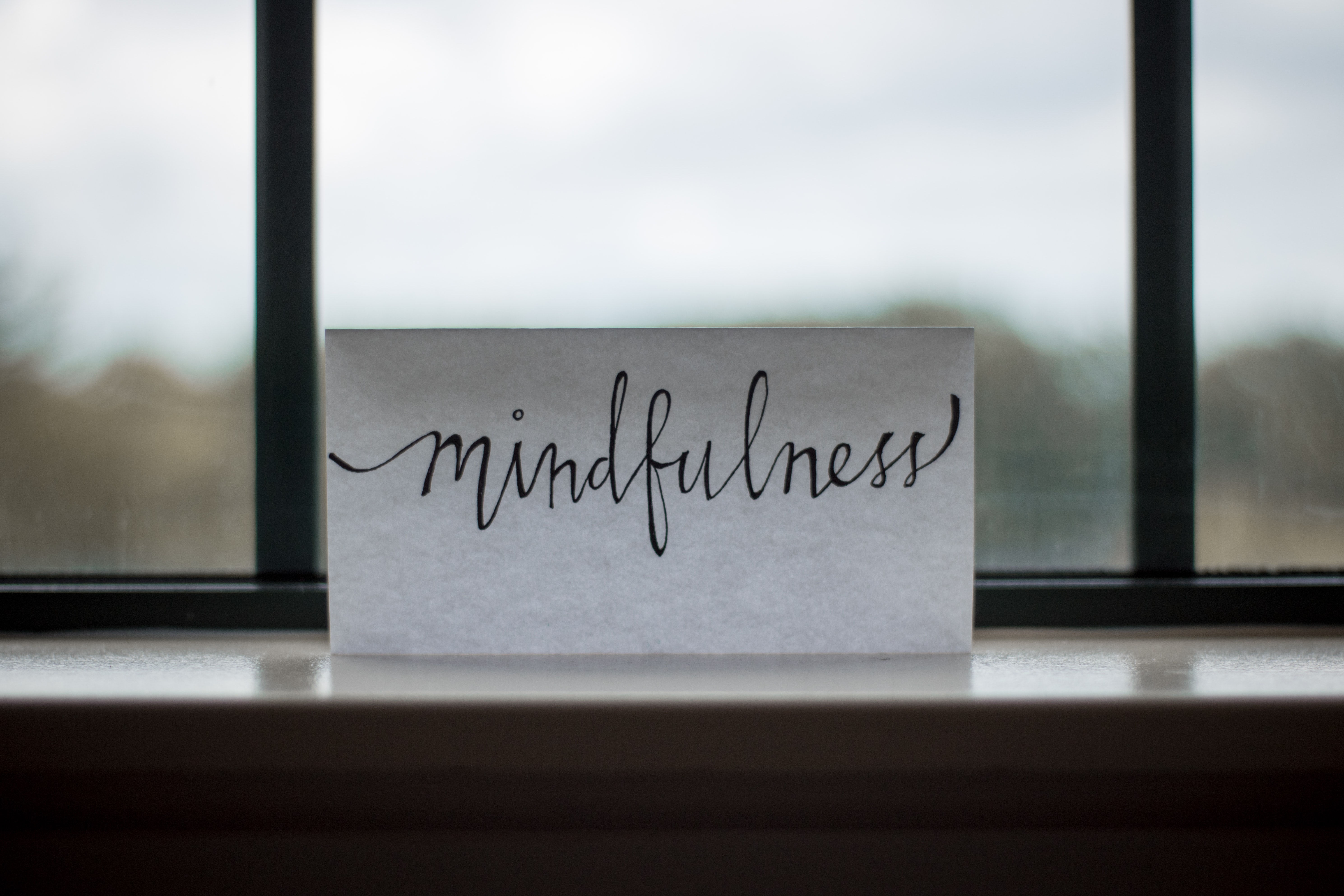 paper with mindfulness written on, positioned near a window.