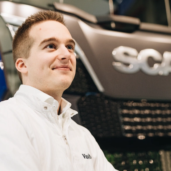 Supply Chain & Operations professional staat naast vrachtwagen van Scania.