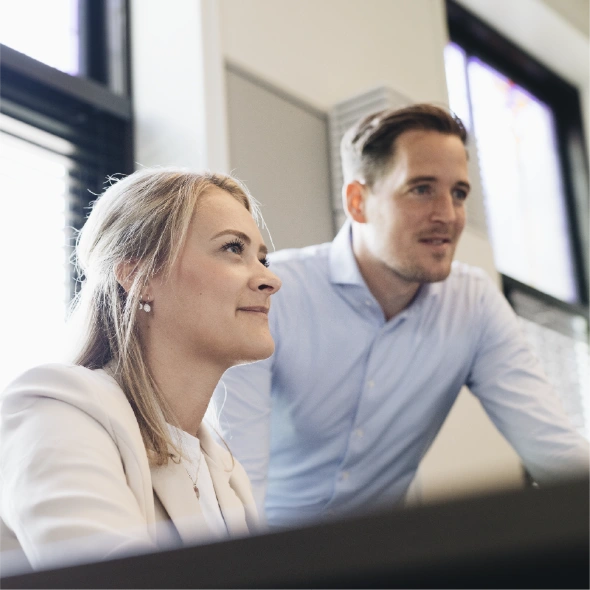 Twee collega's van detacheringsbureau en opleider NextGen kijken naar computerscherm.