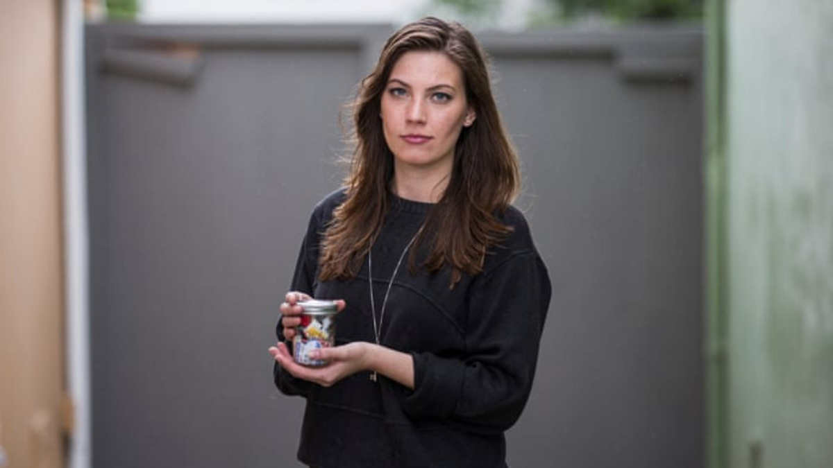 Kathryn Kellogg (Going Zero Waste) a zero-waste blogger holding a year's worth of trash in a small jar
