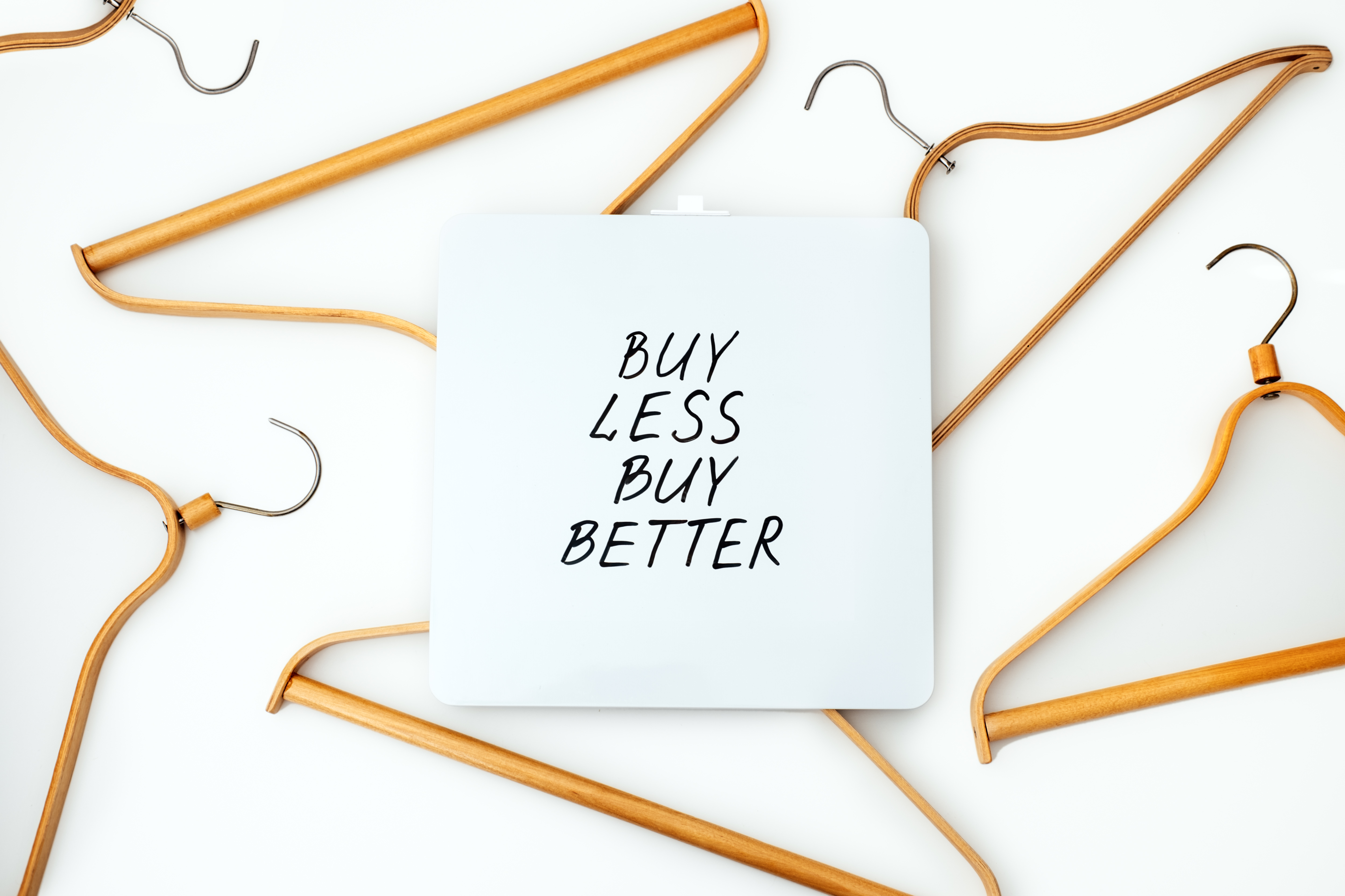Image of cloth hanger saying buy less buy better, encouraging sustainable purchase