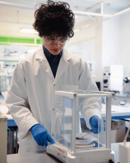 A person in a lab coat using medical apparatus