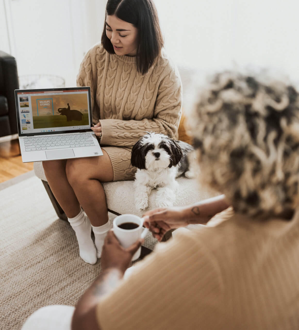 Woman going through a laptop presentation with a dog next to her
