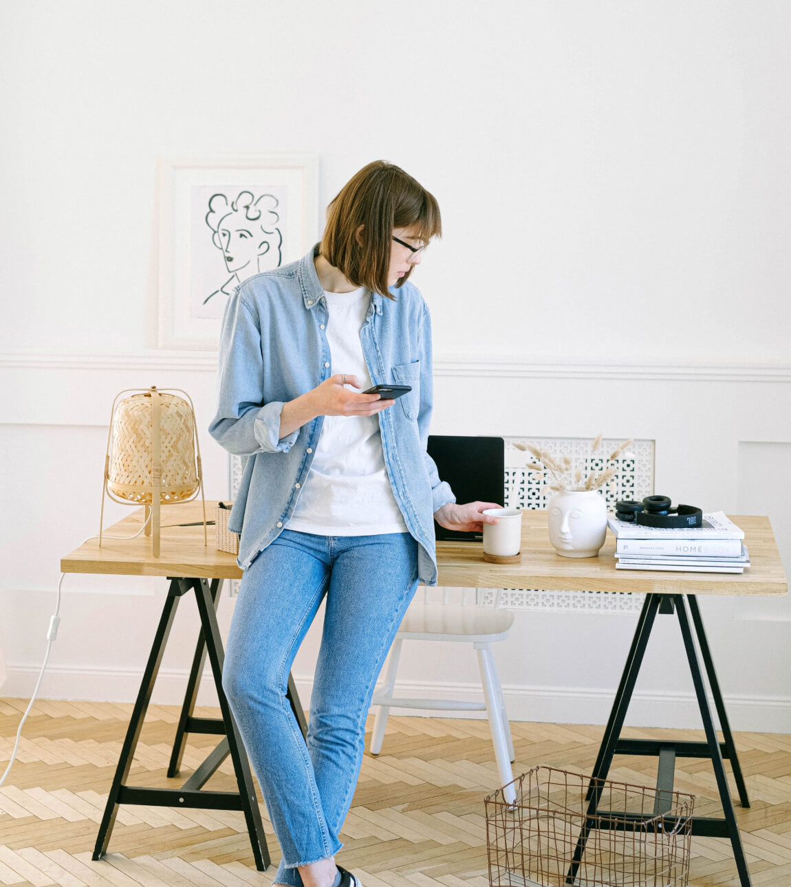Woman in denim outfit on her phone in her home office