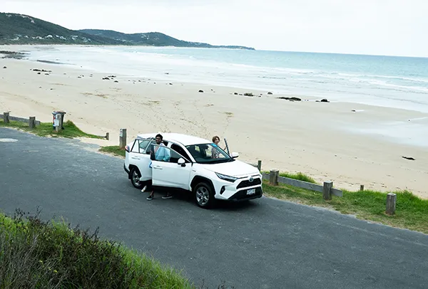 Family on the white car side by beach