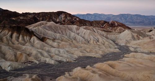 RFPnetworks Economic Research on Liquidity depicted by dry river bed between mountains.