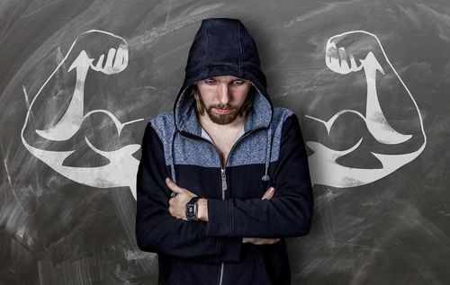 RFPnetworks Investment Grade Credit Research depicted by man in hoody with chalk board behind him with flexed arms.