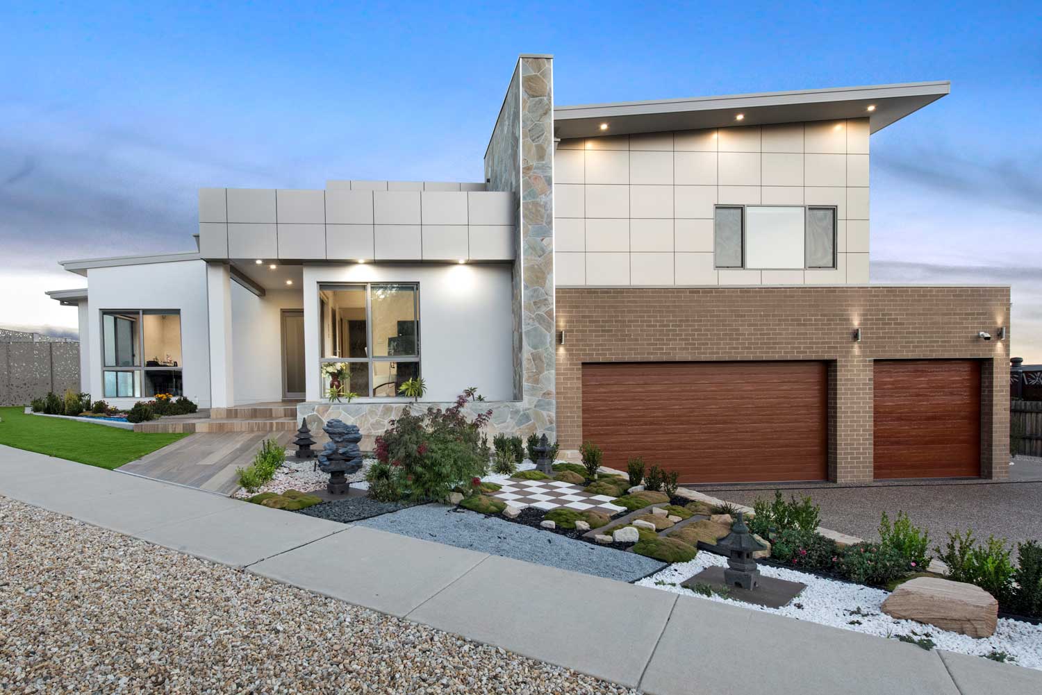 A stunning modern home from the front at sunset.