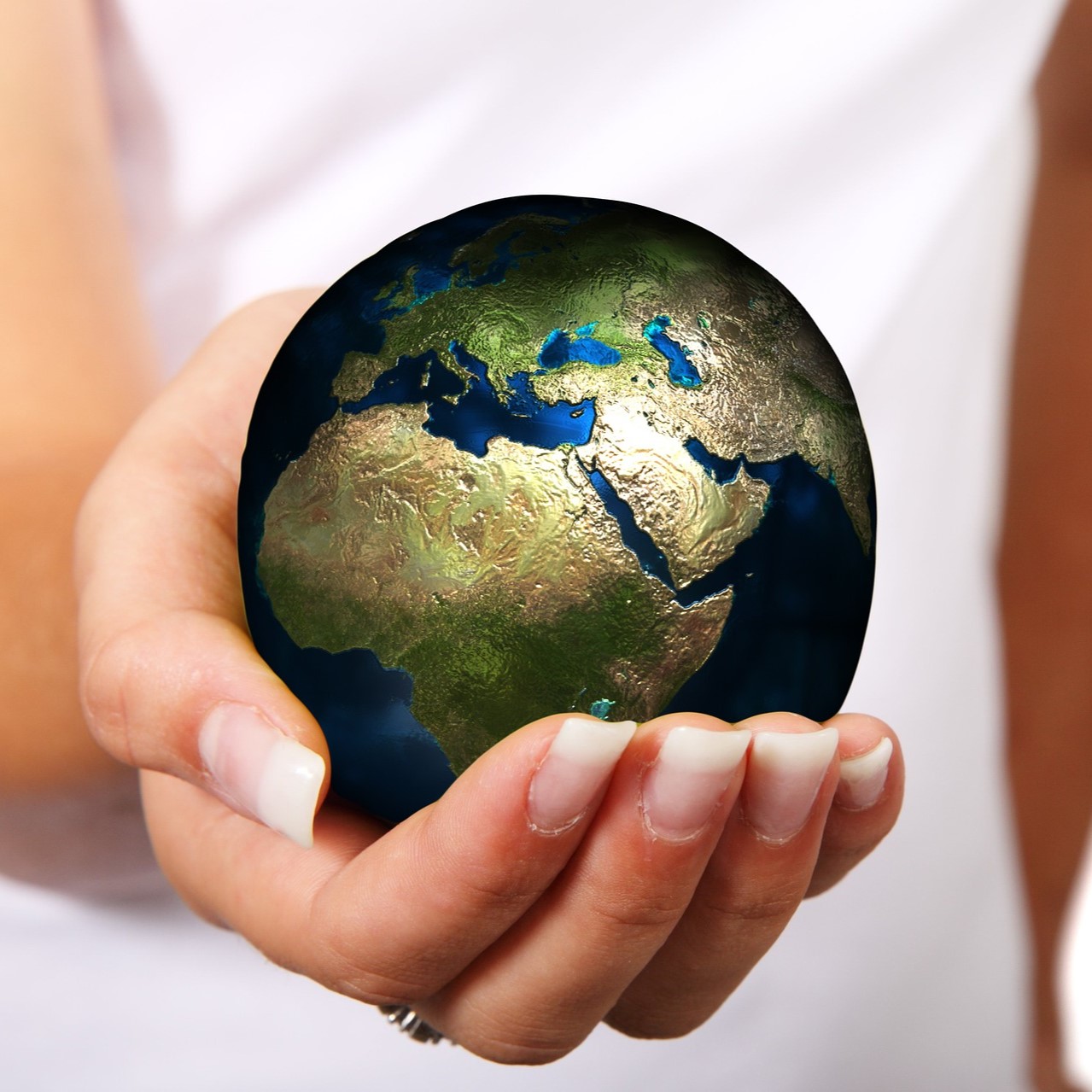 A woman's hand holding a globe with care
