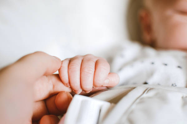 Baby gripping mother's hand
