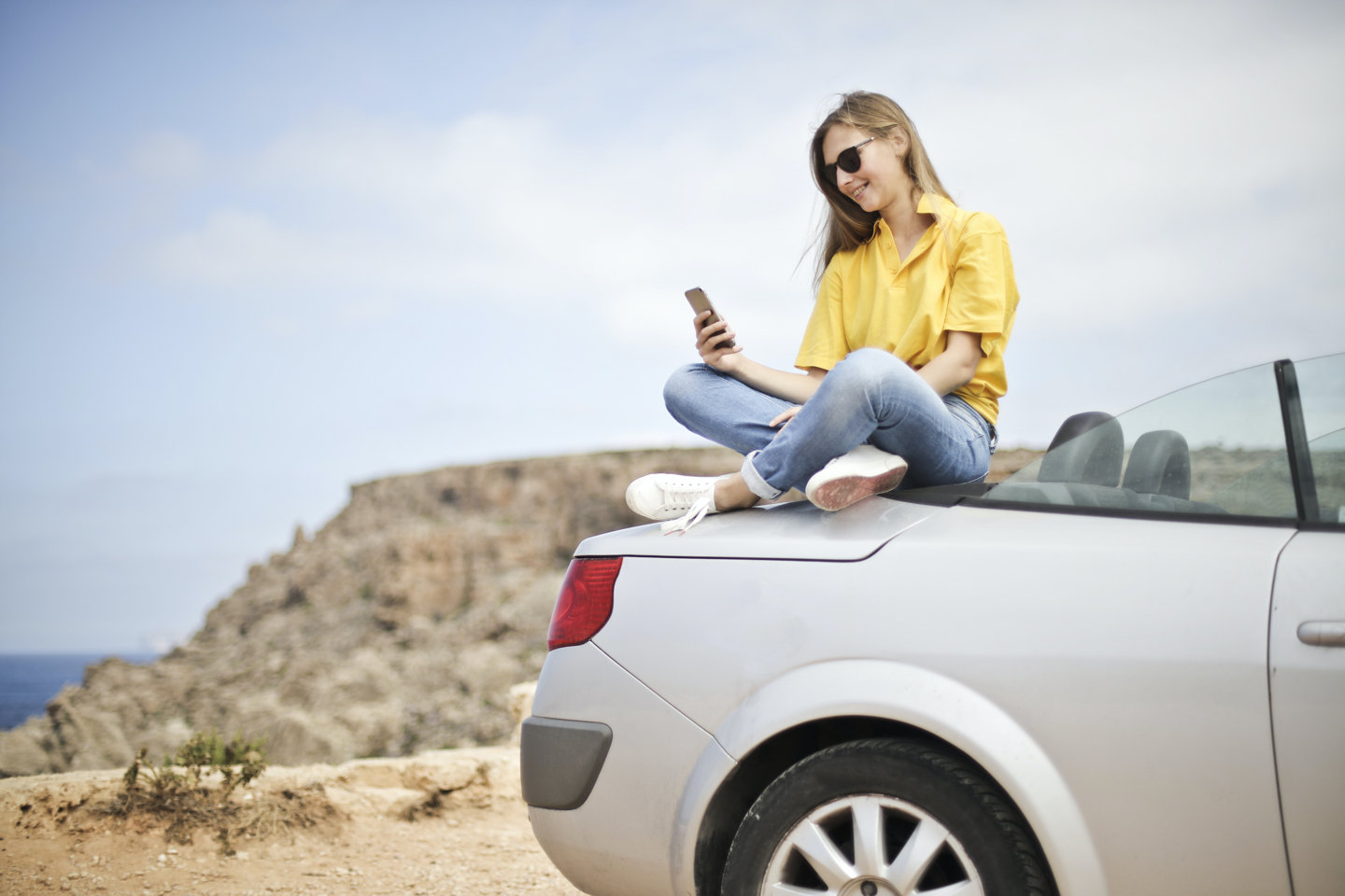 Woman sitting on car