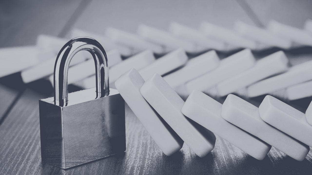 Dominoes leaning on a padlock