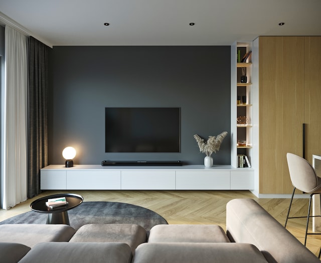 Salon avec téléviseur sur un mur gris