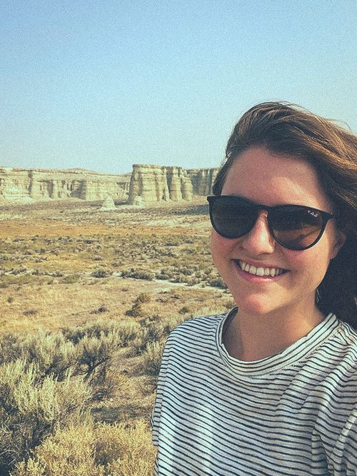 Jessika Tofte standing in front of the geologic formation "The Pillars of Rome" in Oregon which is named for its resemblance to the temple ruins of Rome, Italy.