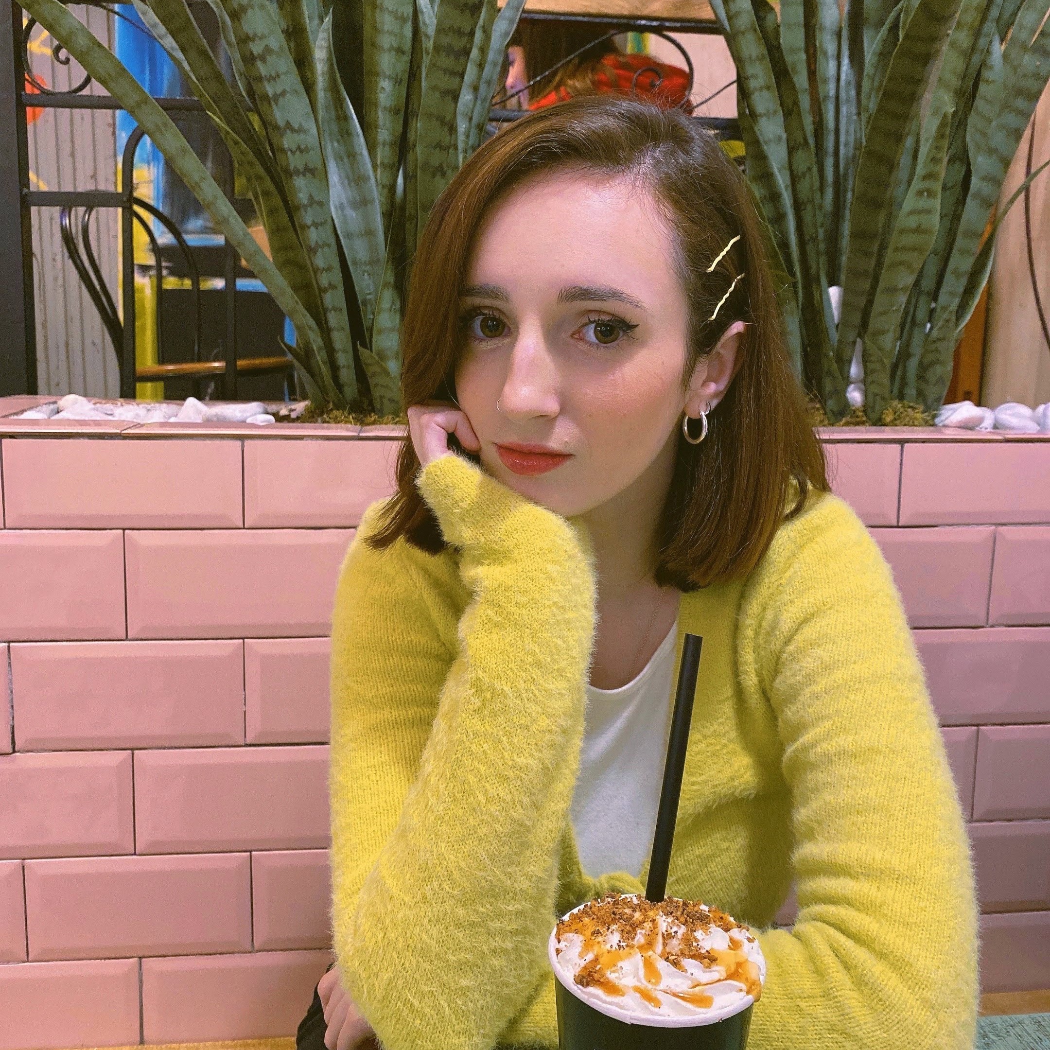 A girl sitting with a coffee on the table