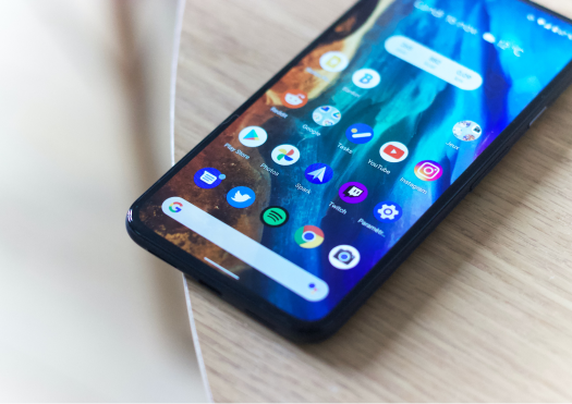 Close up of an Android phone on the corner of a wooden table