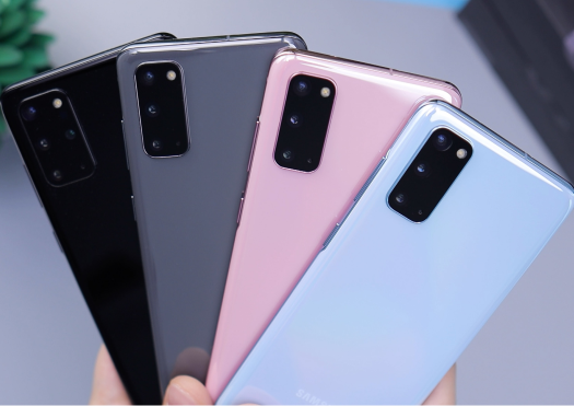 Close up of a person holding four different-colored Samsung phones